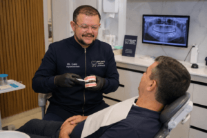 Dr. Caio orientando paciente sobre a limpeza correta do protocolo dentário em Campinas, São Paulo.